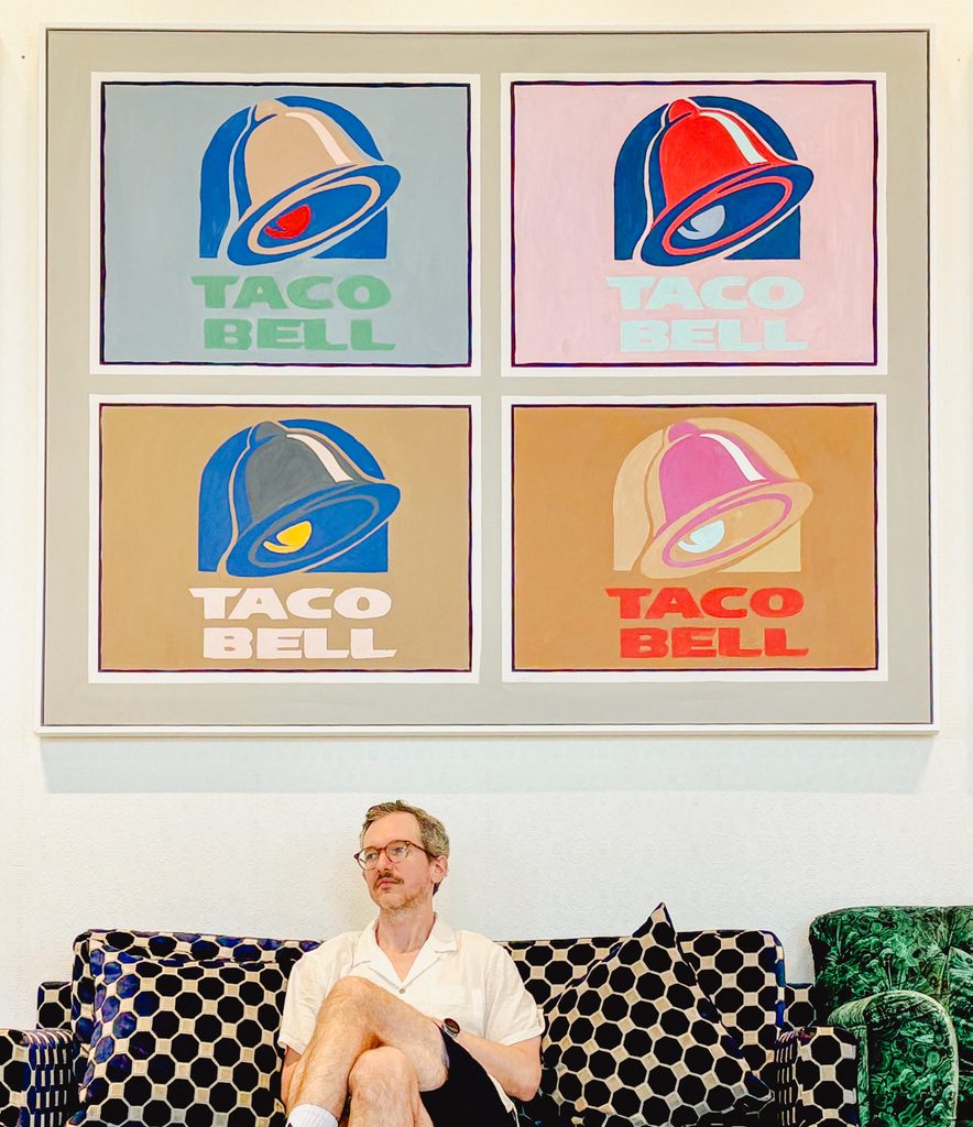 taco bell sign with guy underneath